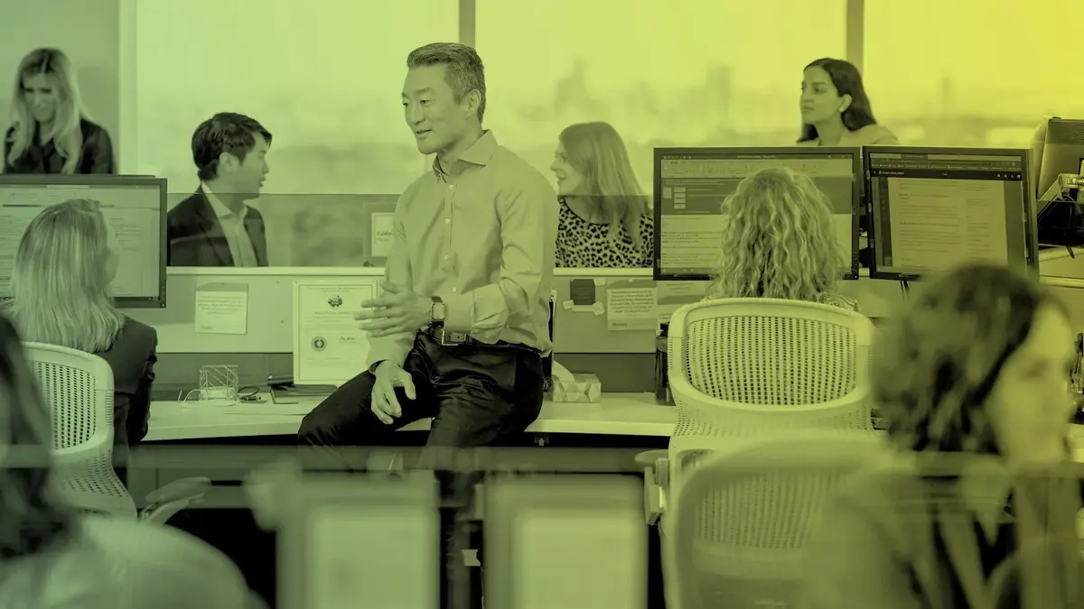 Dimensional employees collaborating at their desks.